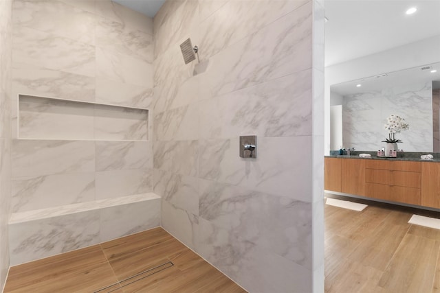 3941 Adrian Dr, Dallas, TX 75209 - full bath featuring a tile shower, double vanity, wood finished floors, and recessed lighting
