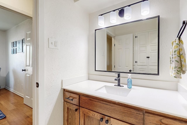 1803 Travis St, Garland, TX 75042 - bathroom with vanity, a textured wall, and wood finished floors