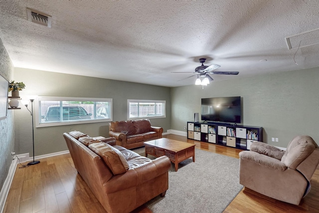 1803 Travis St, Garland, TX 75042 - living room featuring light wood-style floors, a textured ceiling, and ceiling fan