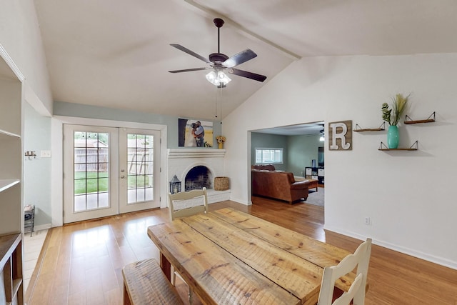 1803 Travis St, Garland, TX 75042 - dining area with a ceiling fan, lofted ceiling, wood finished floors, french doors, and a fireplace