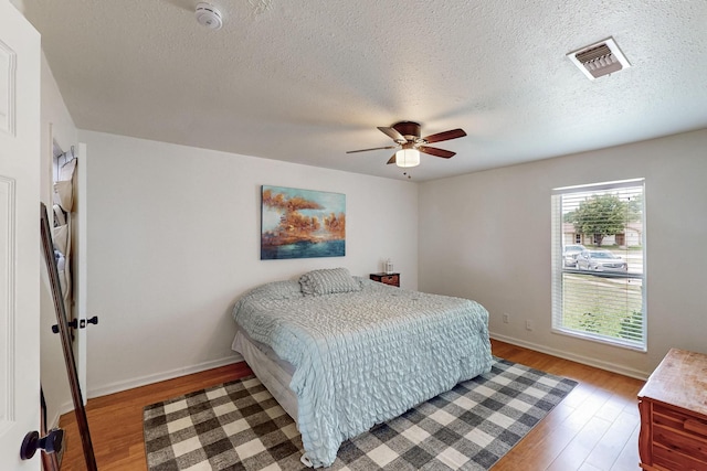 1803 Travis St, Garland, TX 75042 - bedroom featuring light wood-style flooring, a ceiling fan, and a textured ceiling