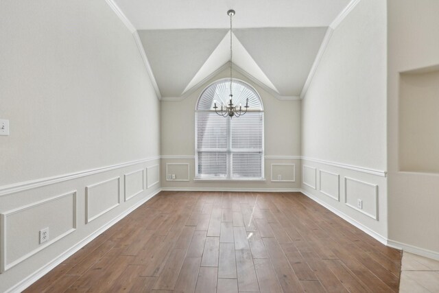 8208 Lonesome Spur Trl, Mckinney, TX 75070 - unfurnished dining area featuring a chandelier, wood finished floors, a wainscoted wall, ornamental molding, and a decorative wall