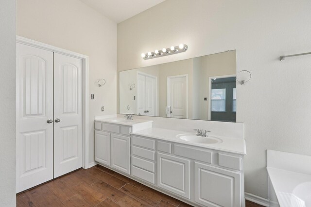 8208 Lonesome Spur Trl, Mckinney, TX 75070 - full bathroom featuring double vanity, wood finished floors, and a tub