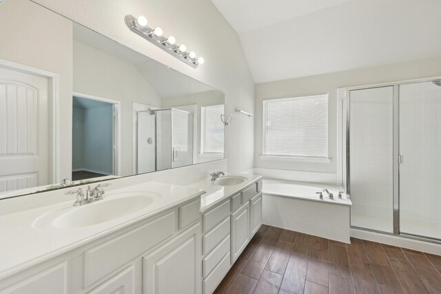 8208 Lonesome Spur Trl, Mckinney, TX 75070 - bathroom featuring vaulted ceiling, double vanity, a shower stall, a bath, and wood finished floors