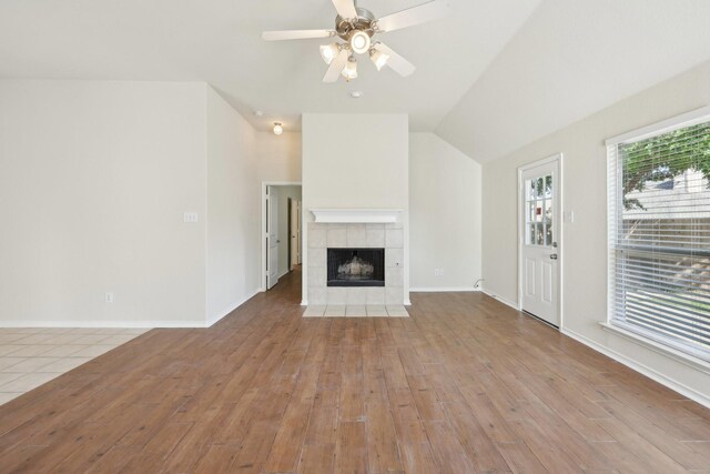8208 Lonesome Spur Trl, Mckinney, TX 75070 - unfurnished living room featuring ceiling fan, a fireplace, wood finished floors, baseboards, and lofted ceiling