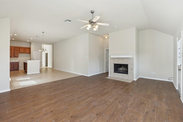 8208 Lonesome Spur Trl, Mckinney, TX 75070 - unfurnished living room with light wood-style flooring, recessed lighting, a tile fireplace, a ceiling fan, and baseboards