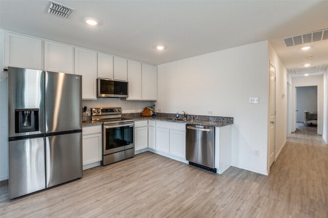 236 Jethro Ln, Princeton, TX 75407 - kitchen featuring stainless steel appliances, light wood-style floors, white cabinets, dark stone counters, and recessed lighting