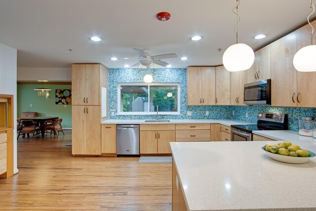 921 NW 9th St, Grand Prairie, TX 75050 - kitchen with stainless steel appliances, light brown cabinets, a sink, light wood-style flooring, and decorative backsplash