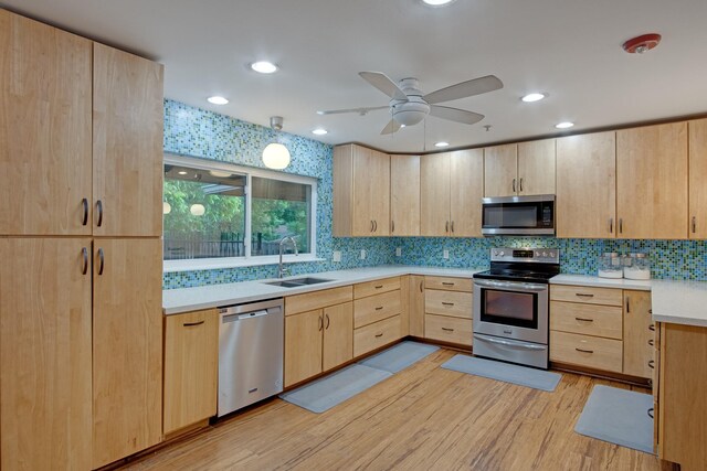 921 NW 9th St, Grand Prairie, TX 75050 - kitchen with stainless steel appliances, light brown cabinets, a sink, light wood finished floors, and light countertops