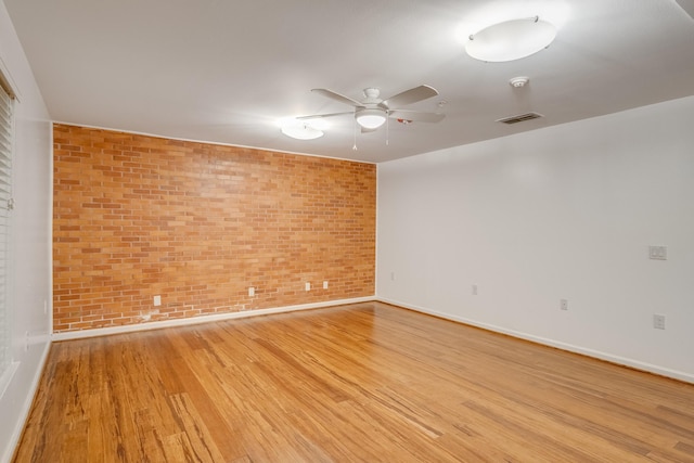 921 NW 9th St, Grand Prairie, TX 75050 - unfurnished room featuring light wood finished floors, a ceiling fan, baseboards, brick wall, and a smoke detector