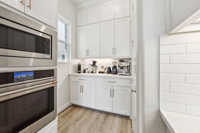 2560 Liverpool Ln, Carrollton, TX 75010 - kitchen with appliances with stainless steel finishes, white cabinets, light countertops, and light wood-style flooring