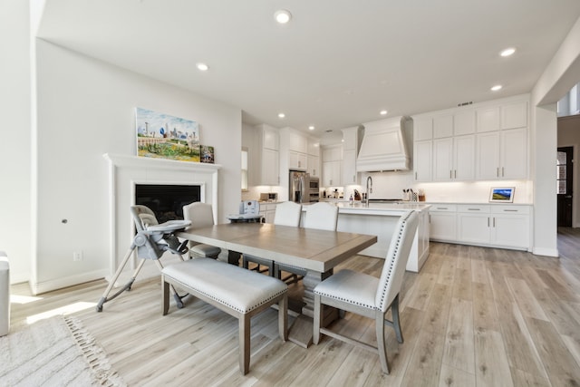 2560 Liverpool Ln, Carrollton, TX 75010 - dining space with light wood-style floors, a fireplace, recessed lighting, and baseboards