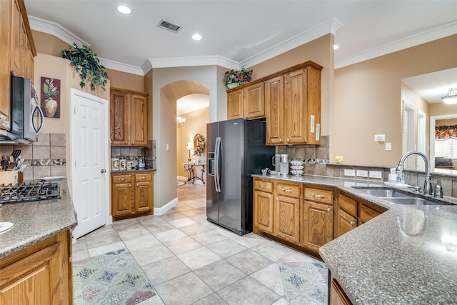2345 Falls View Dr, Rockwall, TX 75087 - kitchen featuring a sink, stainless steel microwave, fridge with ice dispenser, arched walkways, and backsplash