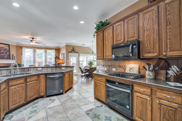 2345 Falls View Dr, Rockwall, TX 75087 - kitchen with stainless steel appliances, a sink, brown cabinetry, ornamental molding, and tasteful backsplash