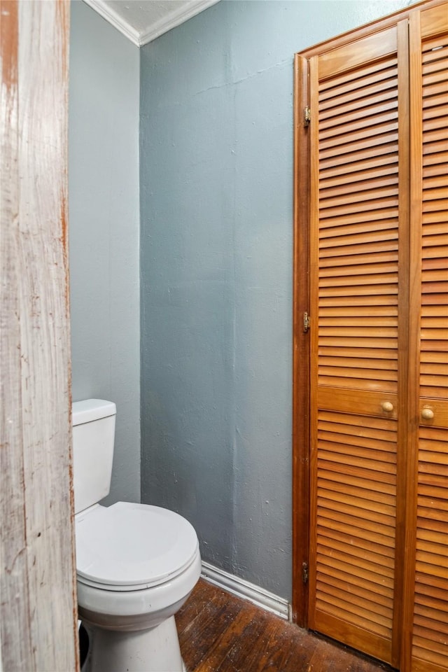 821 Columbia St, Beverly Hills, TX 76711 - bathroom featuring wood finished floors, ornamental molding, toilet, and baseboards