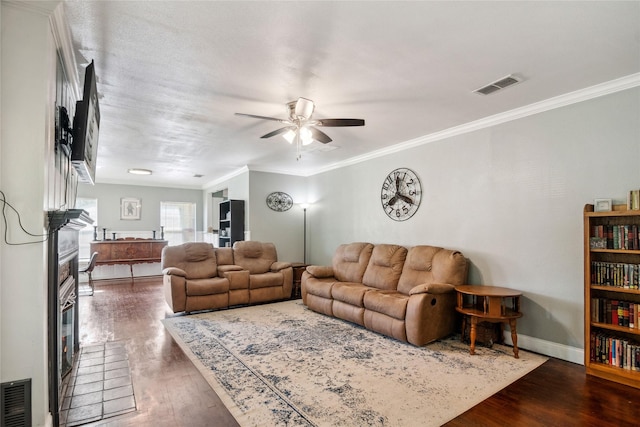 821 Columbia St, Beverly Hills, TX 76711 - living area with wood finished floors, a ceiling fan, a fireplace, ornamental molding, and baseboards