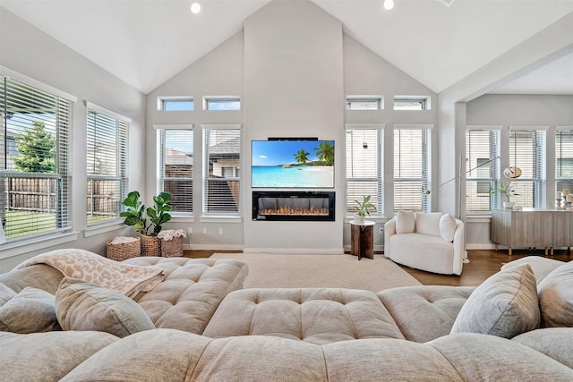 3580 Spruce Hills St, Frisco, TX 75033 - living room featuring plenty of natural light, baseboards, a glass covered fireplace, recessed lighting, and high vaulted ceiling