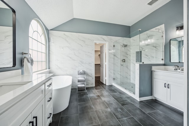 4433 Buchanan Dr, Plano, TX 75024 - full bathroom featuring a marble finish shower, two vanities, a freestanding bath, a spacious closet, and a textured ceiling