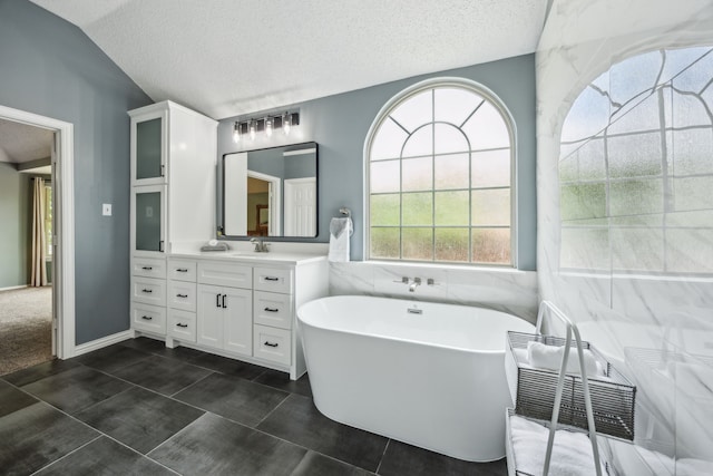 4433 Buchanan Dr, Plano, TX 75024 - bathroom with vanity, a soaking tub, a textured ceiling, and vaulted ceiling