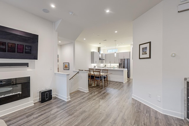 1813 Park Ave Unit 204, Dallas, TX 75215 - living area featuring light wood-type flooring, a glass covered fireplace, baseboards, and recessed lighting