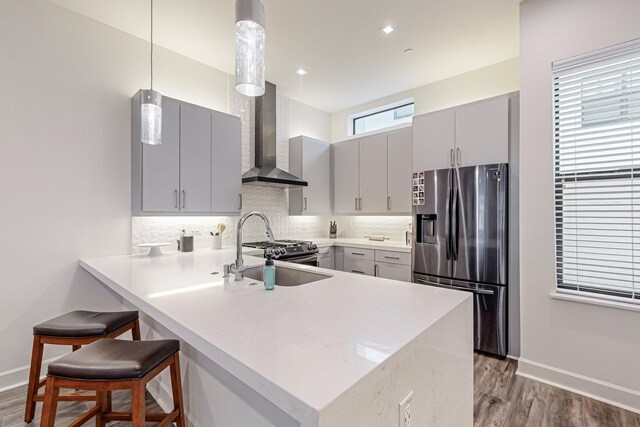 1813 Park Ave Unit 204, Dallas, TX 75215 - kitchen featuring stainless steel appliances, gray cabinetry, wall chimney range hood, a sink, and a peninsula