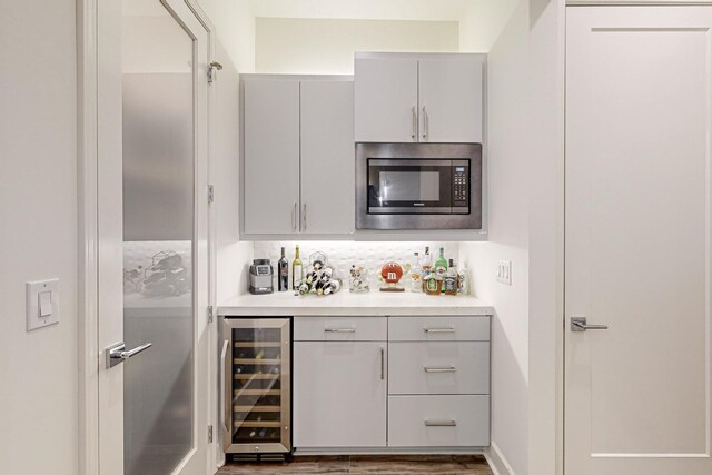1813 Park Ave Unit 204, Dallas, TX 75215 - indoor dry bar with beverage cooler, stainless steel microwave, decorative backsplash, and wood finished floors