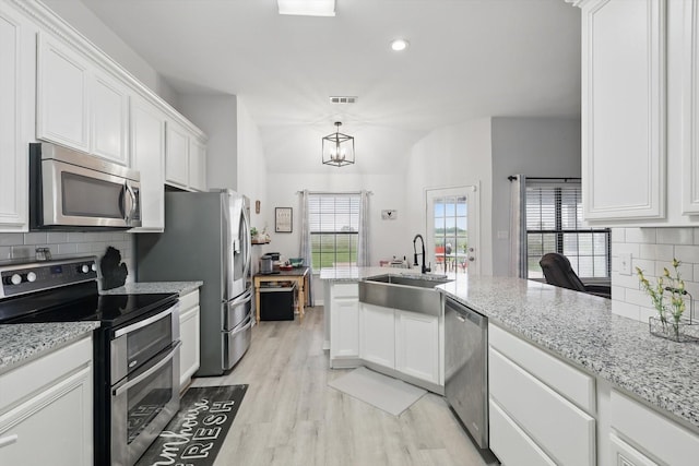 205 N Armstrong Rd, Venus, TX 76084 - kitchen featuring appliances with stainless steel finishes, a sink, white cabinets, light wood-style flooring, and tasteful backsplash