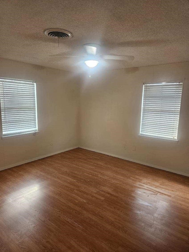 1100 8th St, Cooper, TX 75432 - unfurnished room featuring wood finished floors, baseboards, and a textured ceiling
