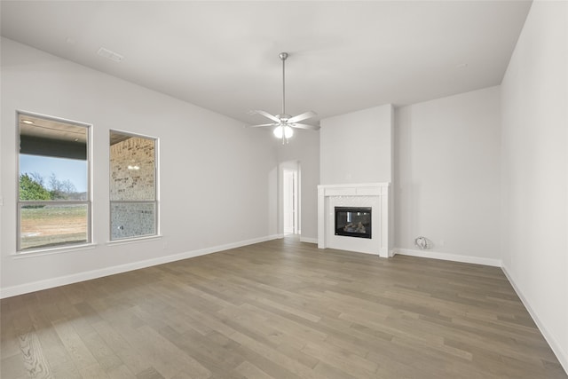 6013 Valley View Dr, Joshua, TX 76058 - unfurnished living room featuring wood finished floors, a tiled fireplace, and baseboards