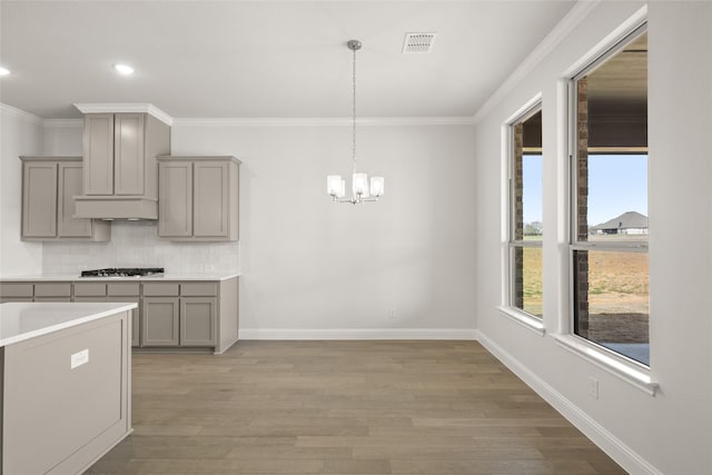 6013 Valley View Dr, Joshua, TX 76058 - kitchen featuring gray cabinets, gas cooktop, a chandelier, crown molding, and tasteful backsplash