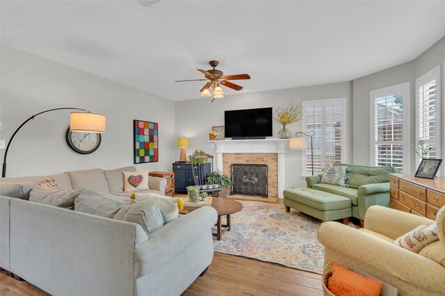 3712 Stockport Dr, Plano, TX 75025 - living area with wood finished floors, a brick fireplace, and a ceiling fan