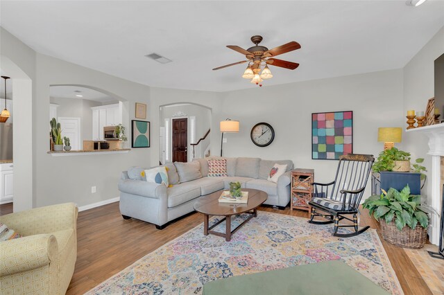3712 Stockport Dr, Plano, TX 75025 - living area featuring arched walkways, a ceiling fan, wood finished floors, and baseboards