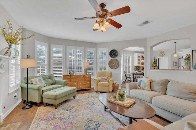 3712 Stockport Dr, Plano, TX 75025 - living room featuring ceiling fan, arched walkways, baseboards, and light wood-style flooring