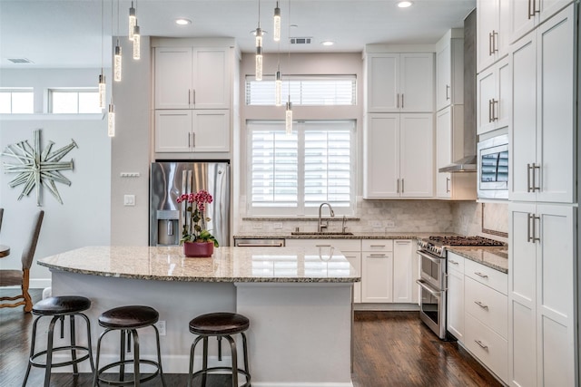 731 Spanish Oaks Pl, Dallas, TX 75204 - kitchen with stainless steel appliances, a sink, dark wood finished floors, a center island, and tasteful backsplash