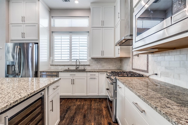 731 Spanish Oaks Pl, Dallas, TX 75204 - kitchen with appliances with stainless steel finishes, a sink, wine cooler, white cabinetry, and plenty of natural light