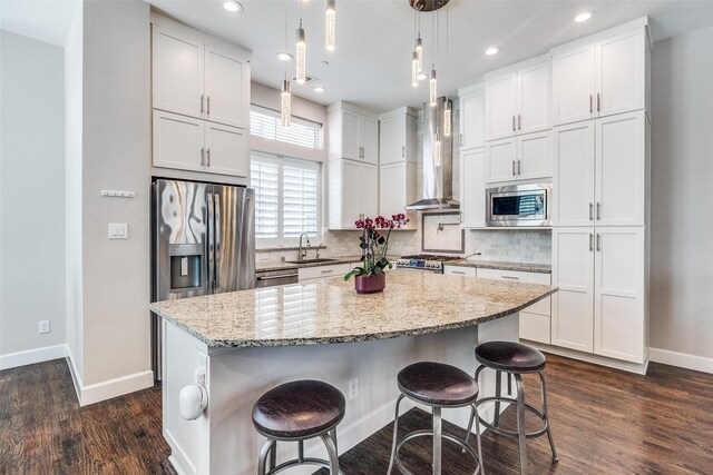 731 Spanish Oaks Pl, Dallas, TX 75204 - kitchen featuring wall chimney range hood, appliances with stainless steel finishes, a sink, baseboards, and white cabinetry