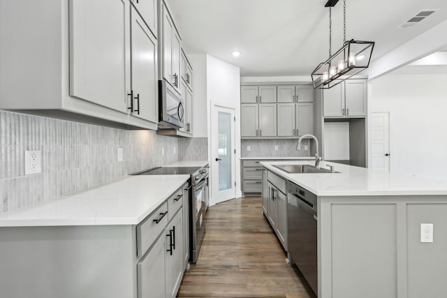 6002 Verde Way, Dallas, TX 75211 - kitchen featuring stainless steel appliances, gray cabinets, a sink, a center island with sink, and wood finished floors