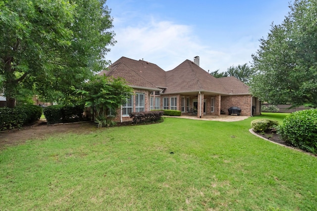 704 Longford Dr, Southlake, TX 76092 - back of house featuring brick siding, a yard, a chimney, and a patio area