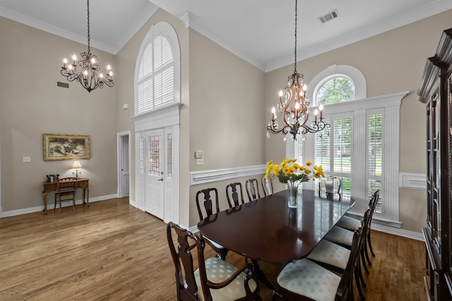 704 Longford Dr, Southlake, TX 76092 - dining area featuring a chandelier, crown molding, a towering ceiling, wood finished floors, and baseboards