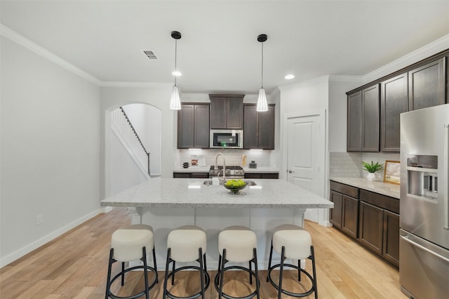 2101 Chebi Ln, Denton, TX 76209 - kitchen featuring appliances with stainless steel finishes, crown molding, light wood finished floors, dark brown cabinetry, and recessed lighting