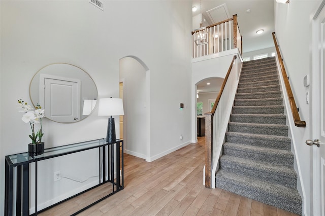 2101 Chebi Ln, Denton, TX 76209 - stairs featuring arched walkways, wood finished floors, and a towering ceiling