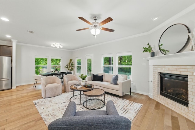 2101 Chebi Ln, Denton, TX 76209 - living area featuring light wood finished floors, a ceiling fan, recessed lighting, crown molding, and a fireplace