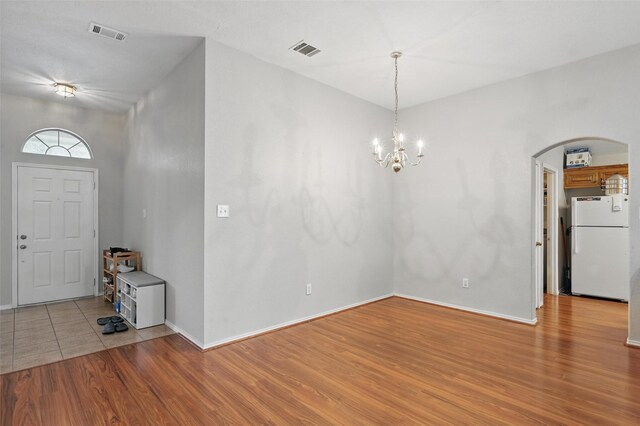 10700 Irish Glen Trl, Haslet, TX 76052 - foyer entrance with arched walkways, light wood finished floors, a chandelier, and baseboards