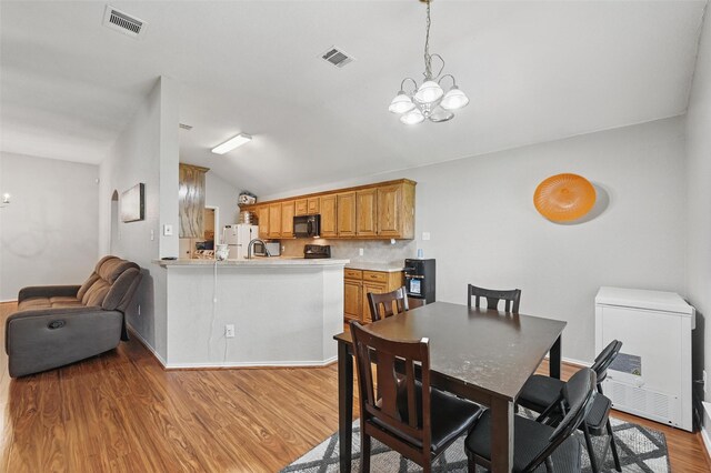 10700 Irish Glen Trl, Haslet, TX 76052 - dining space with vaulted ceiling, a chandelier, light wood-style flooring, and baseboards
