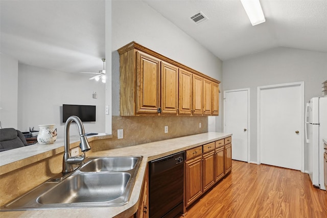 10700 Irish Glen Trl, Haslet, TX 76052 - kitchen featuring a sink, black dishwasher, freestanding refrigerator, brown cabinetry, and vaulted ceiling