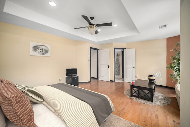 5716 Wall Ave, Haltom City, TX 76117 - bedroom with a tray ceiling, wood finished floors, baseboards, recessed lighting, and a ceiling fan