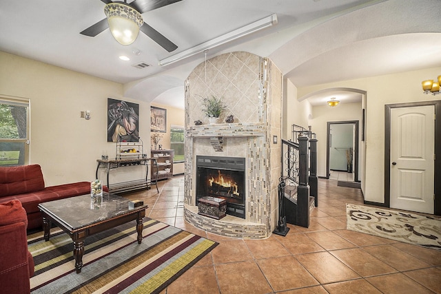 5716 Wall Ave, Haltom City, TX 76117 - living room featuring arched walkways, a ceiling fan, tile patterned floors, a fireplace, and recessed lighting