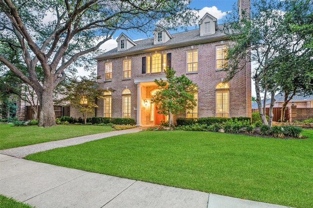 5932 Royal Palm Dr, Plano, TX 75093 - colonial inspired home with a front yard, brick siding, and a chimney