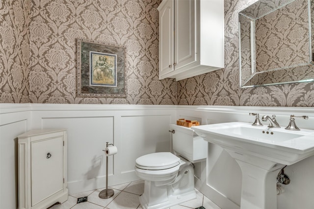 5932 Royal Palm Dr, Plano, TX 75093 - half bathroom with wallpapered walls, wainscoting, toilet, tile patterned flooring, and a sink