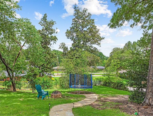 3614 Birdwell Dr, Tyler, TX 75701 - view of green lawn featuring an outdoor fire pit and a trampoline